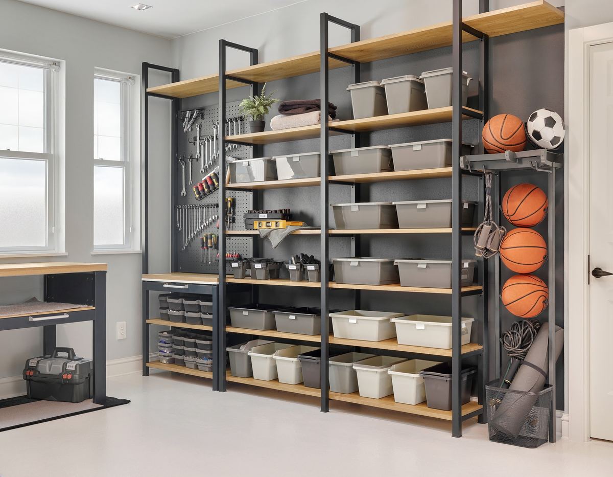 Garage wall with steel-and-oak shelving, matching gray bins, a pegboard of hand tools and a ball rack